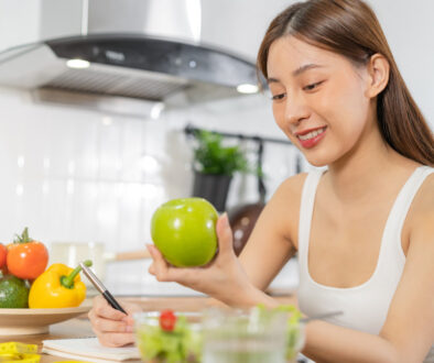 Young Asian Woman Eating a Salad to Follow Women’s Health Preventative Health Care Tips