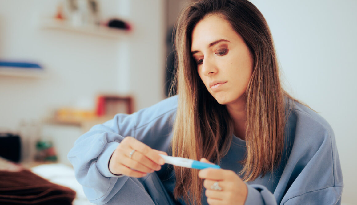 A Woman Examining a Pregnancy Test Wonders How to Test If a Woman is Infertile